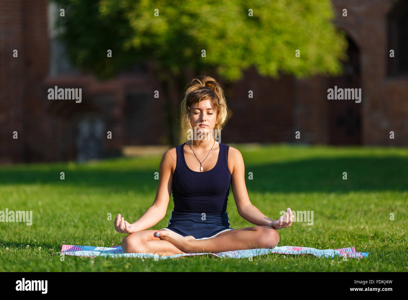 Ragazza giovane e carina facendo esercizi yoga nel parco Foto Stock
