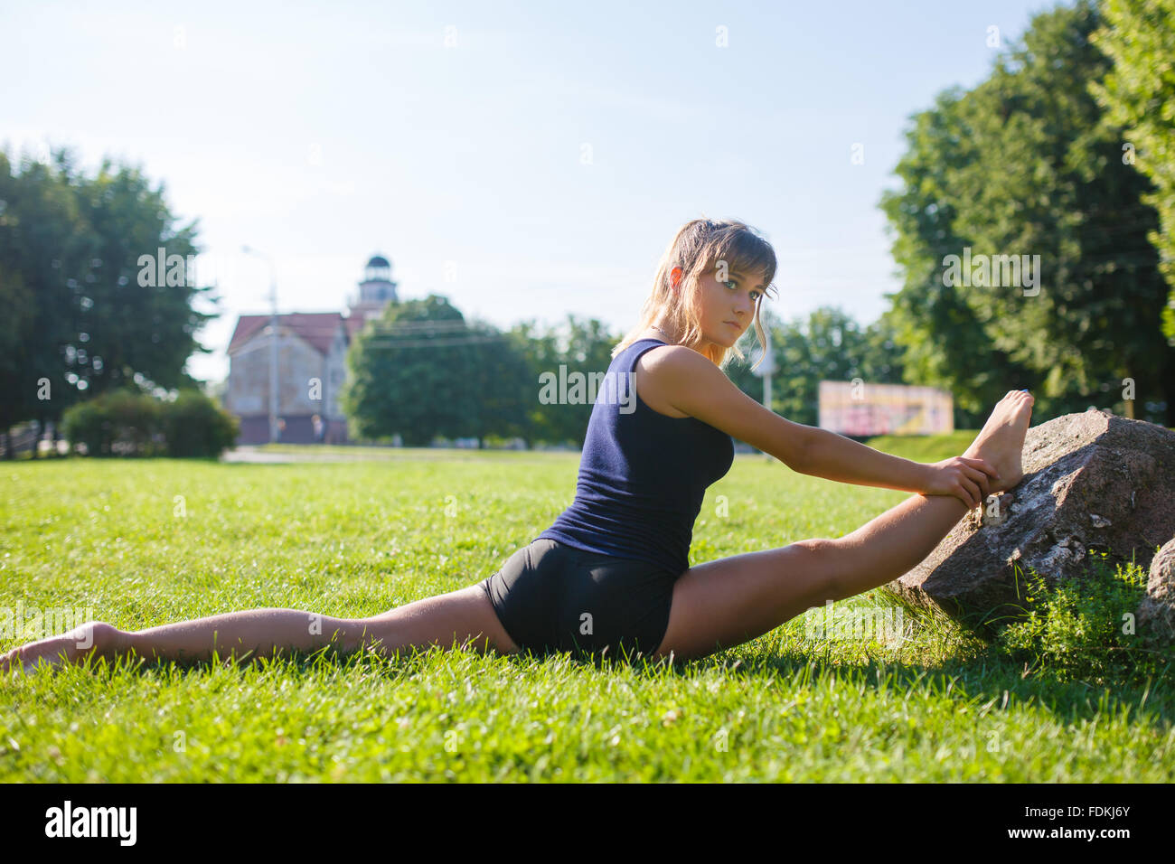 Ragazza giovane e carina facendo esercizi yoga outdoor Foto Stock