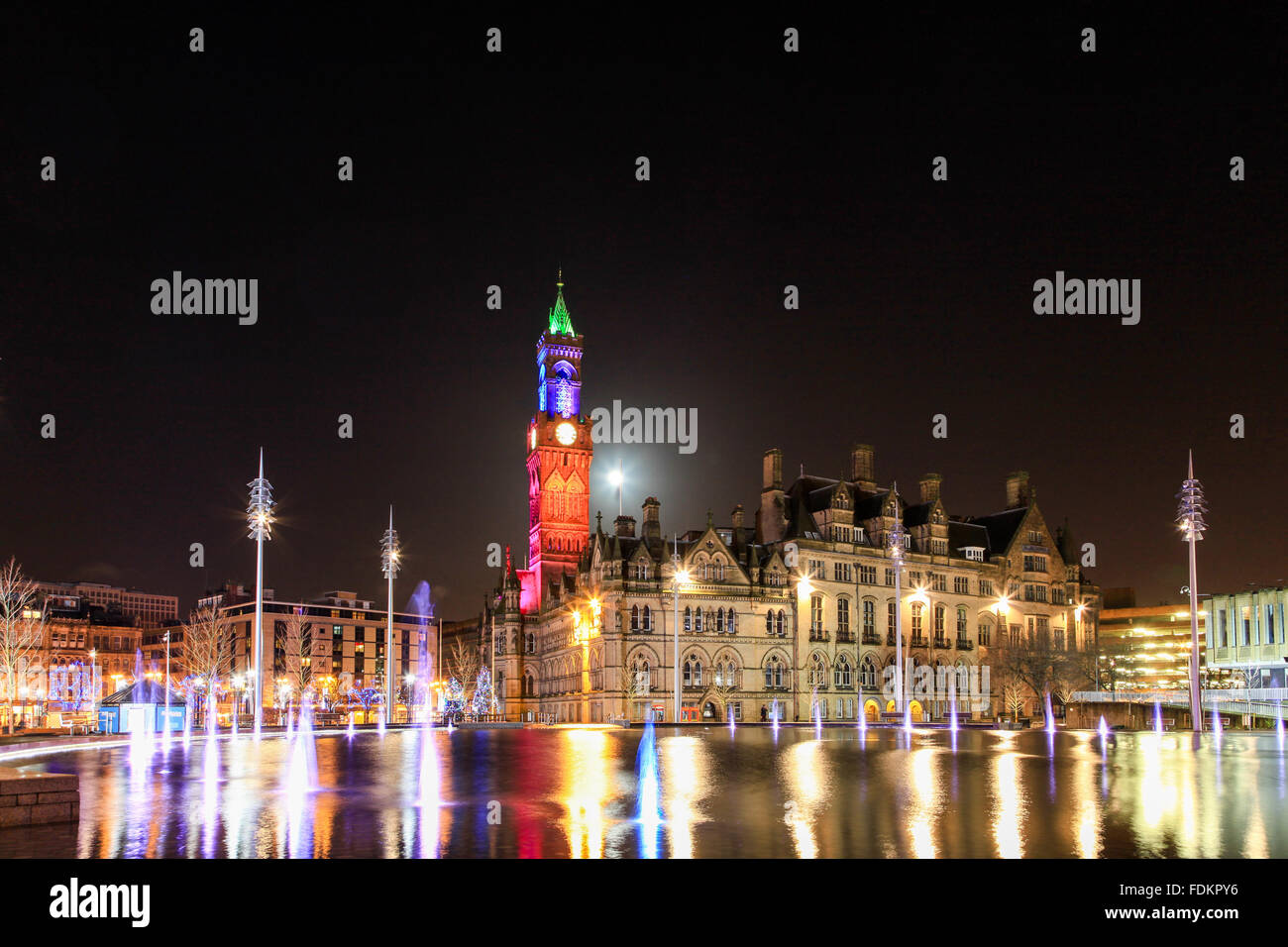 Bradford City Park e Municipio di notte con torre illuminata di colore, Centenary Square, la piscina a specchio d'acqua. Foto Stock