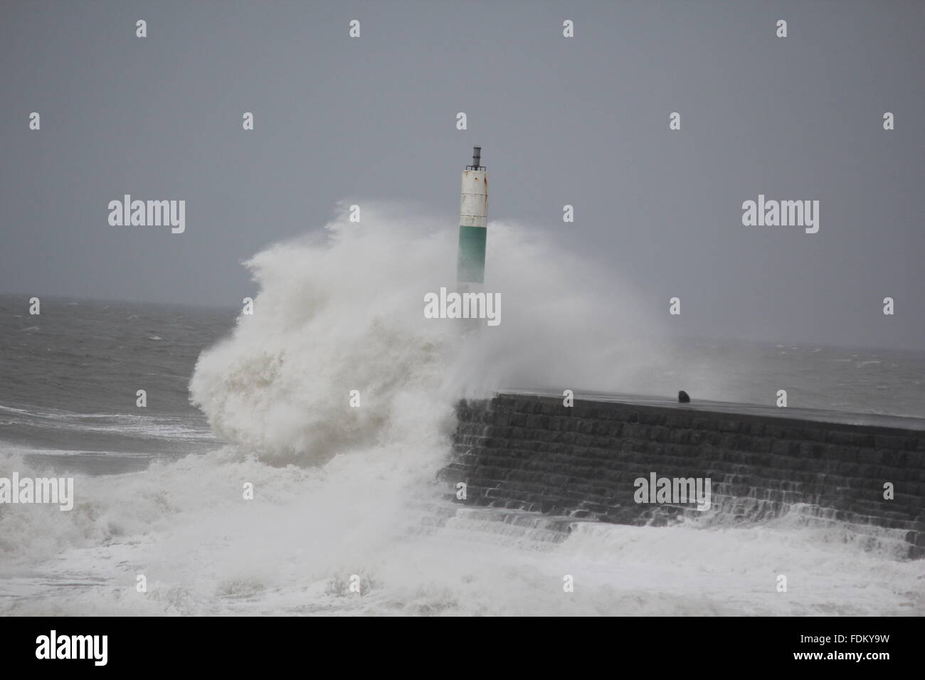Aberystwyth Wales UK, 2016 onde enormi pilotato da gale force venti continuano a pastella le difese del mare del Galles e le regioni occidentali Foto Stock