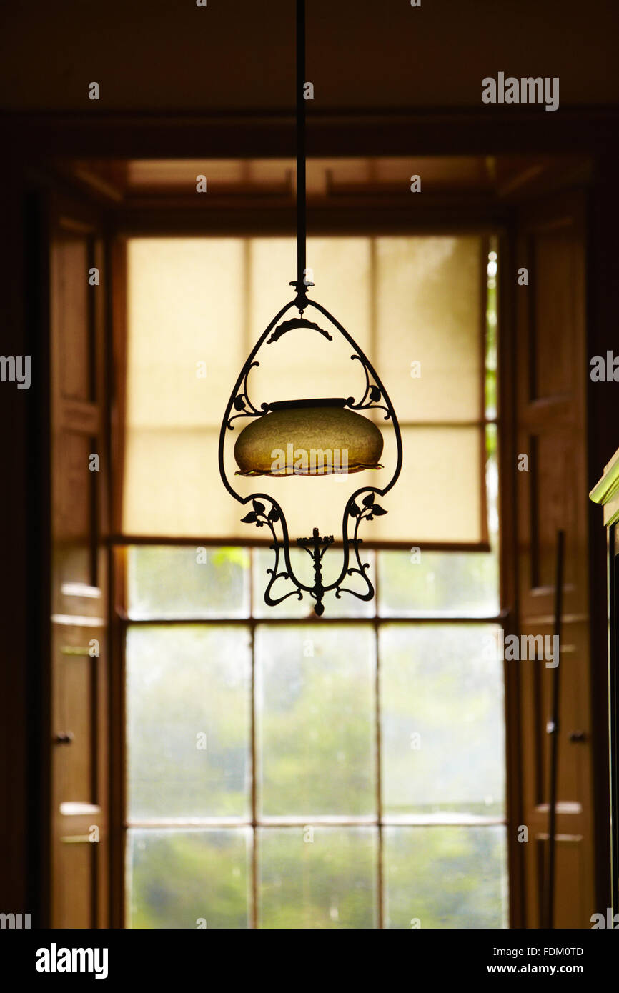 Un ottone "arpa' gas pendente di design in stile Liberty in un passaggio al Argory, nella contea di Armagh. Il vetro acidato sfumature e per il consumatore di fumo sono originali. Un rubinetto gas può essere visto alla base del raccordo. Foto Stock