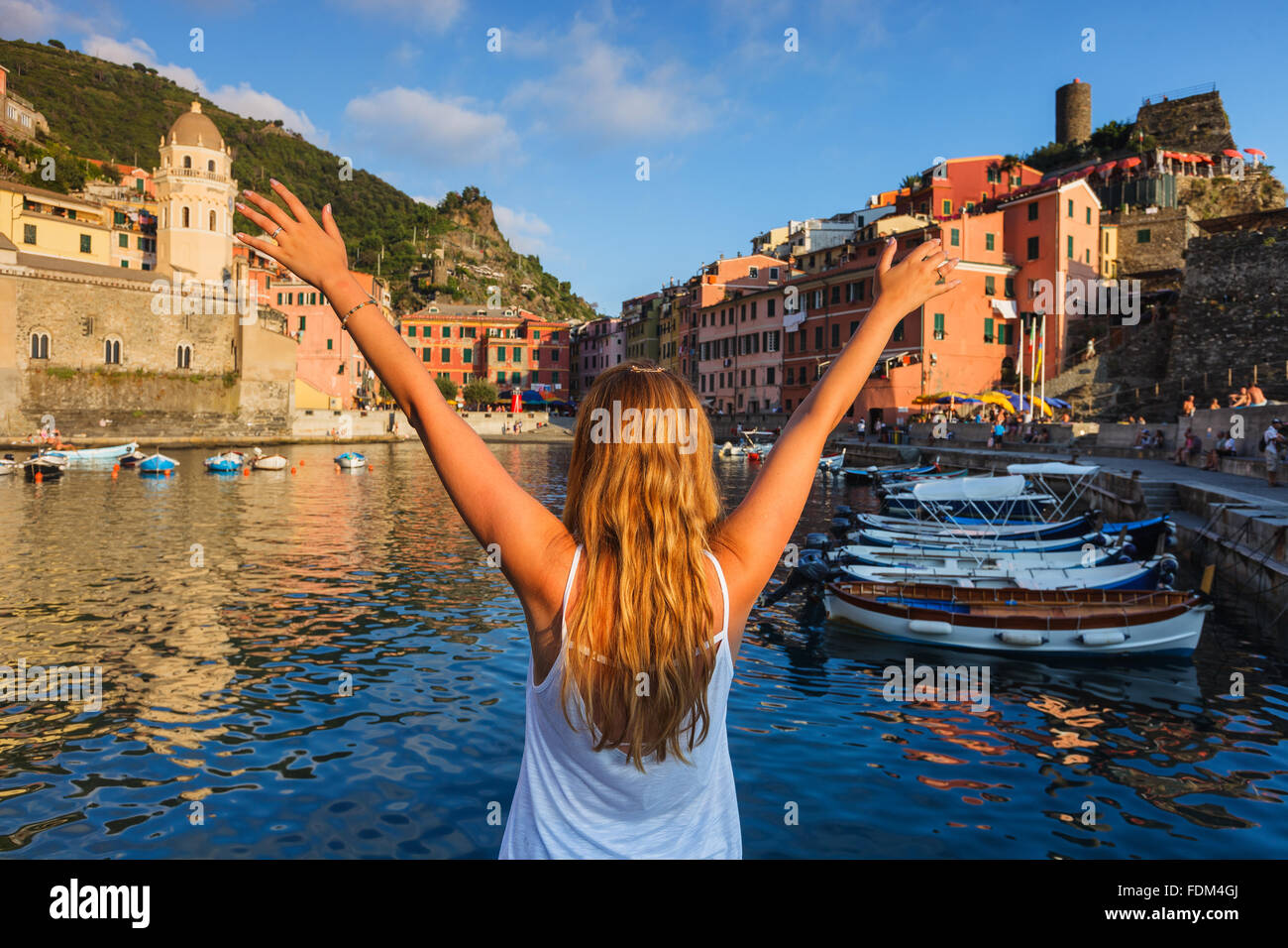 Una giovane donna caucasica rilassante con la vista di Vernazza, Cinque Terre National Park, Liguria, Italia. Foto Stock