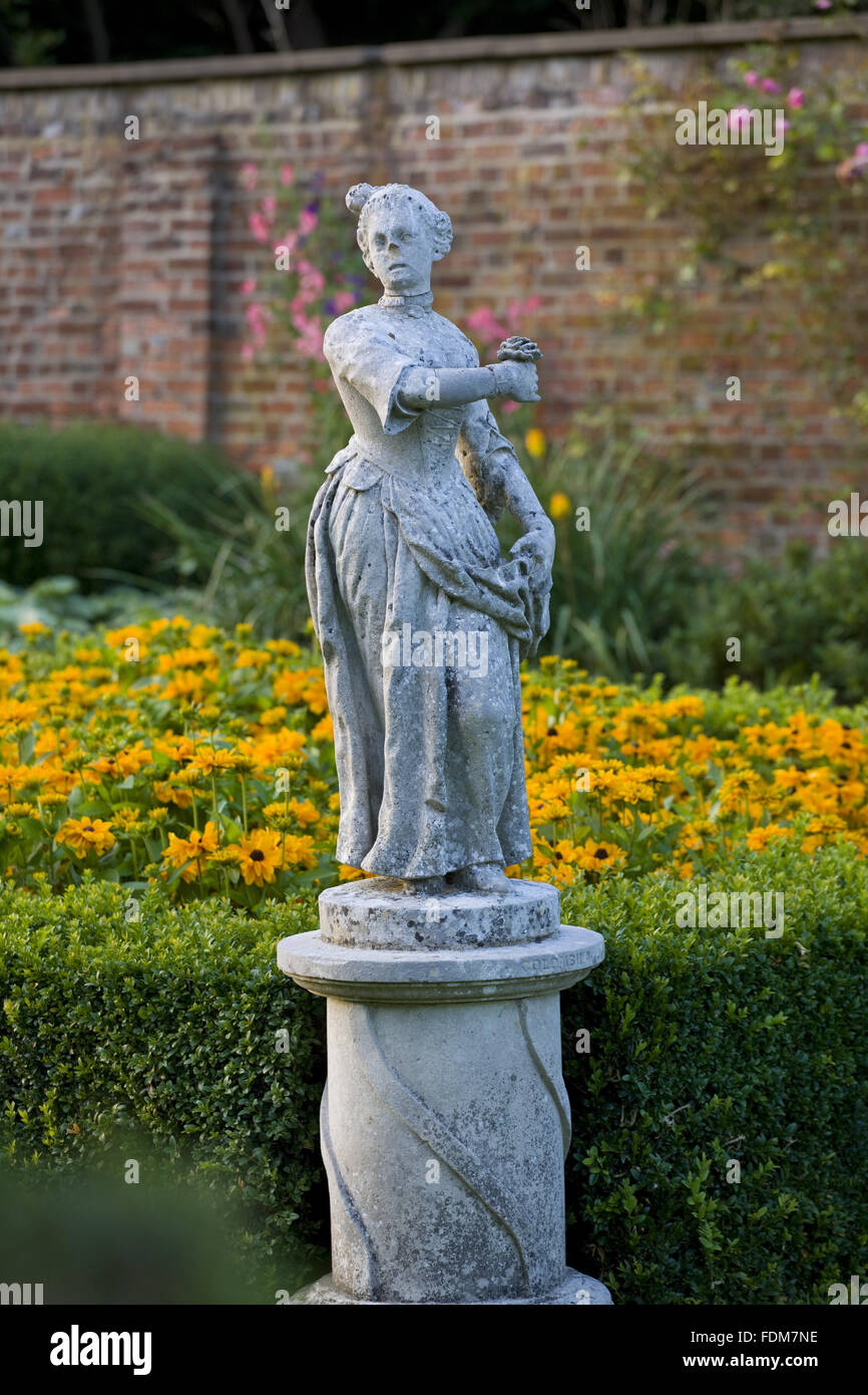 Statua e box-refilato aiuole con Rudbeckia nel lungo giardino a Cliveden, Buckinghamshire, nel mese di agosto alla luce della sera. Foto Stock