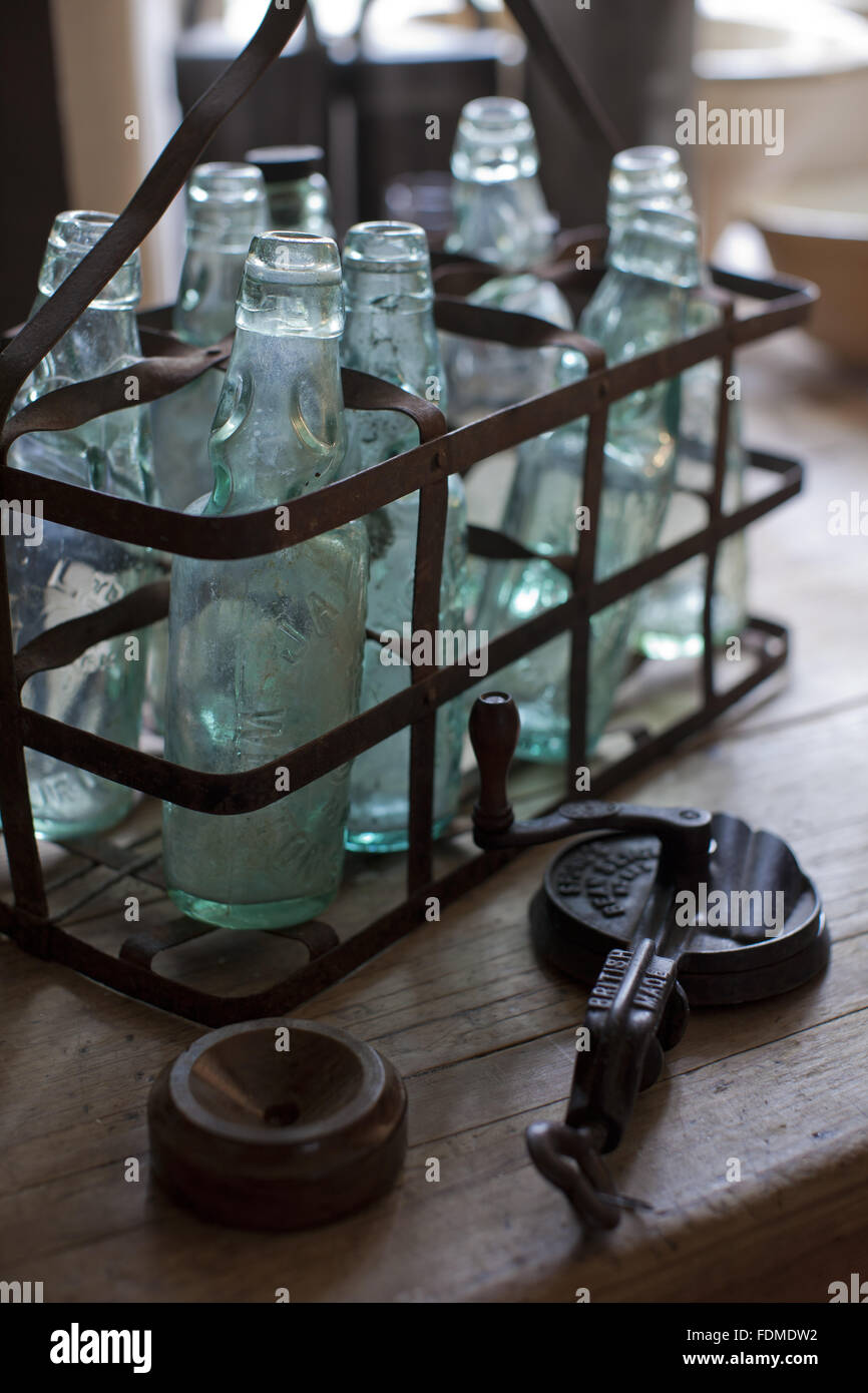 Bottiglie di vetro in una porta filo in cucina ad Avebury Manor, Wiltshire. Foto Stock