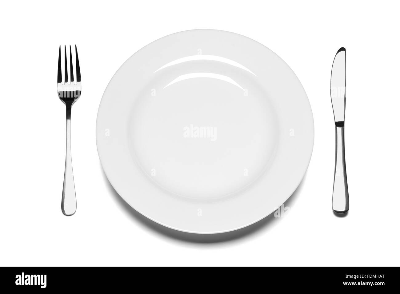 Piastra vuota con coltello e forchetta isolata su uno sfondo bianco. Foto Stock