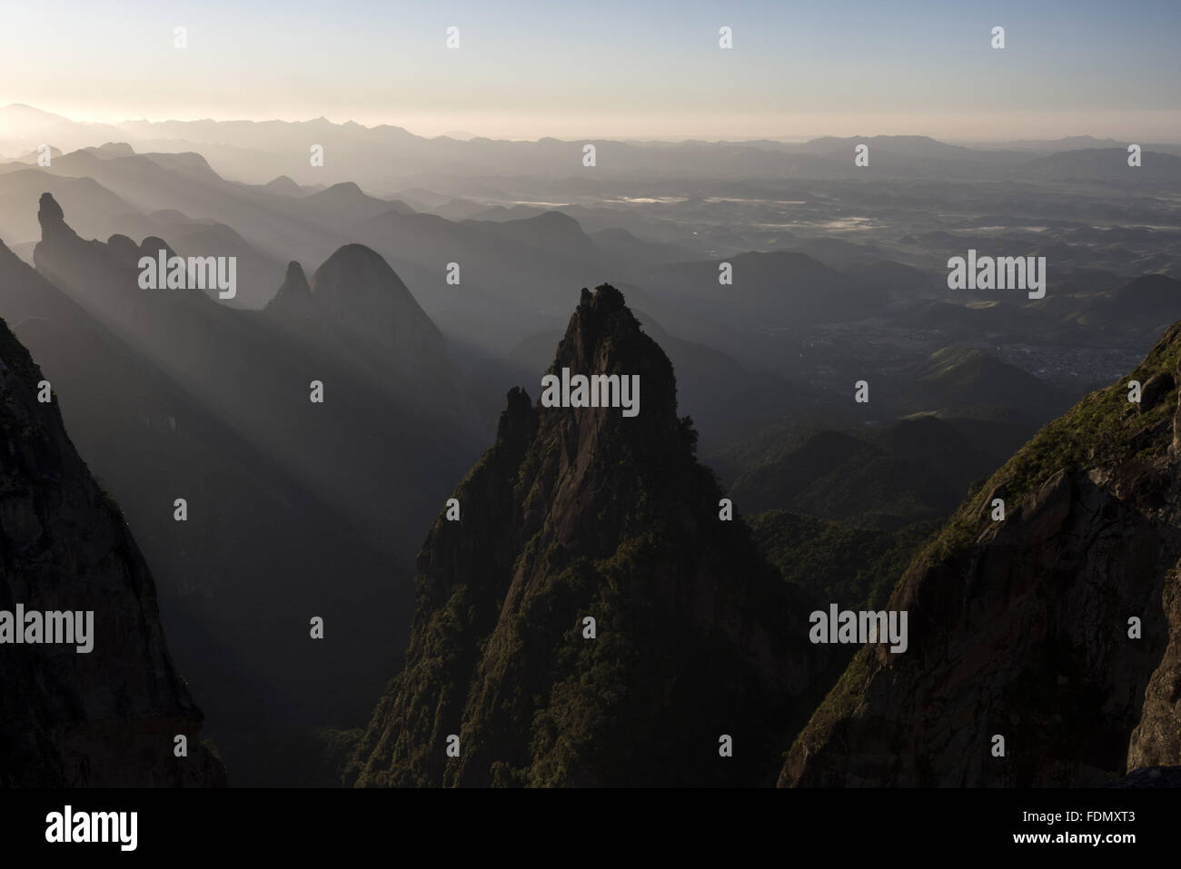 Raios de sol sobre montanhas no Parque Nacional da Serra dos Órgãos com Dedo de Deus à direita Foto Stock