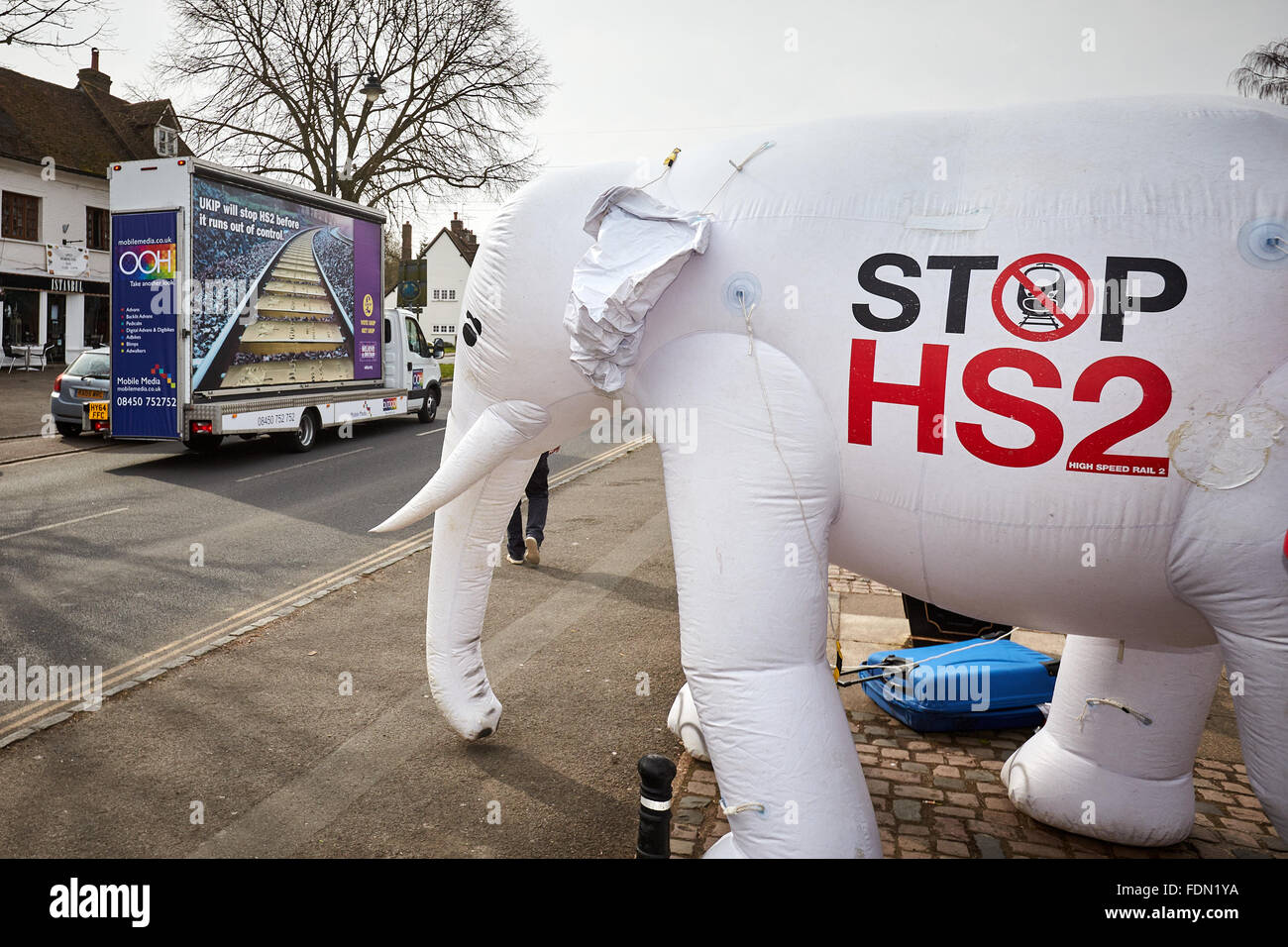 Un'UKIP anti-HS2 poster viene azionata lungo Wendover High Street e oltre il finecorsa HS2 gonfiabile elefante bianco Foto Stock