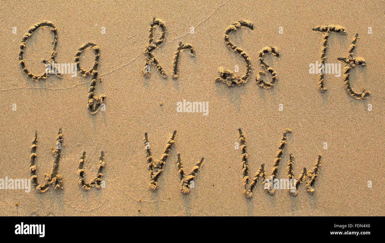 Lettere dell'alfabeto scritta sulla spiaggia sabbiosa (da Q a W) Foto Stock