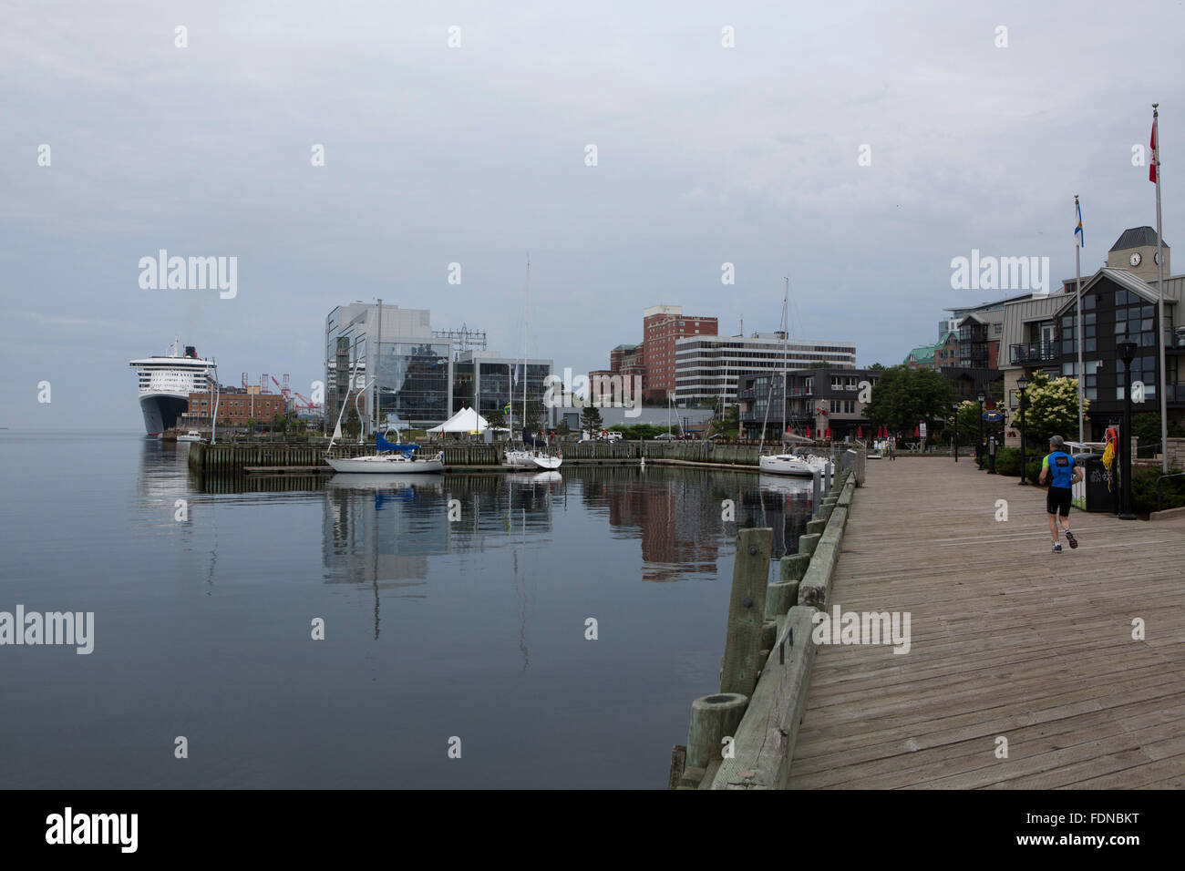 Un uomo fa avanzare sui pontili in legno sul lungomare di Halifax, Canada. I pontili sono un retaggio del commercio di merci in Nova Foto Stock