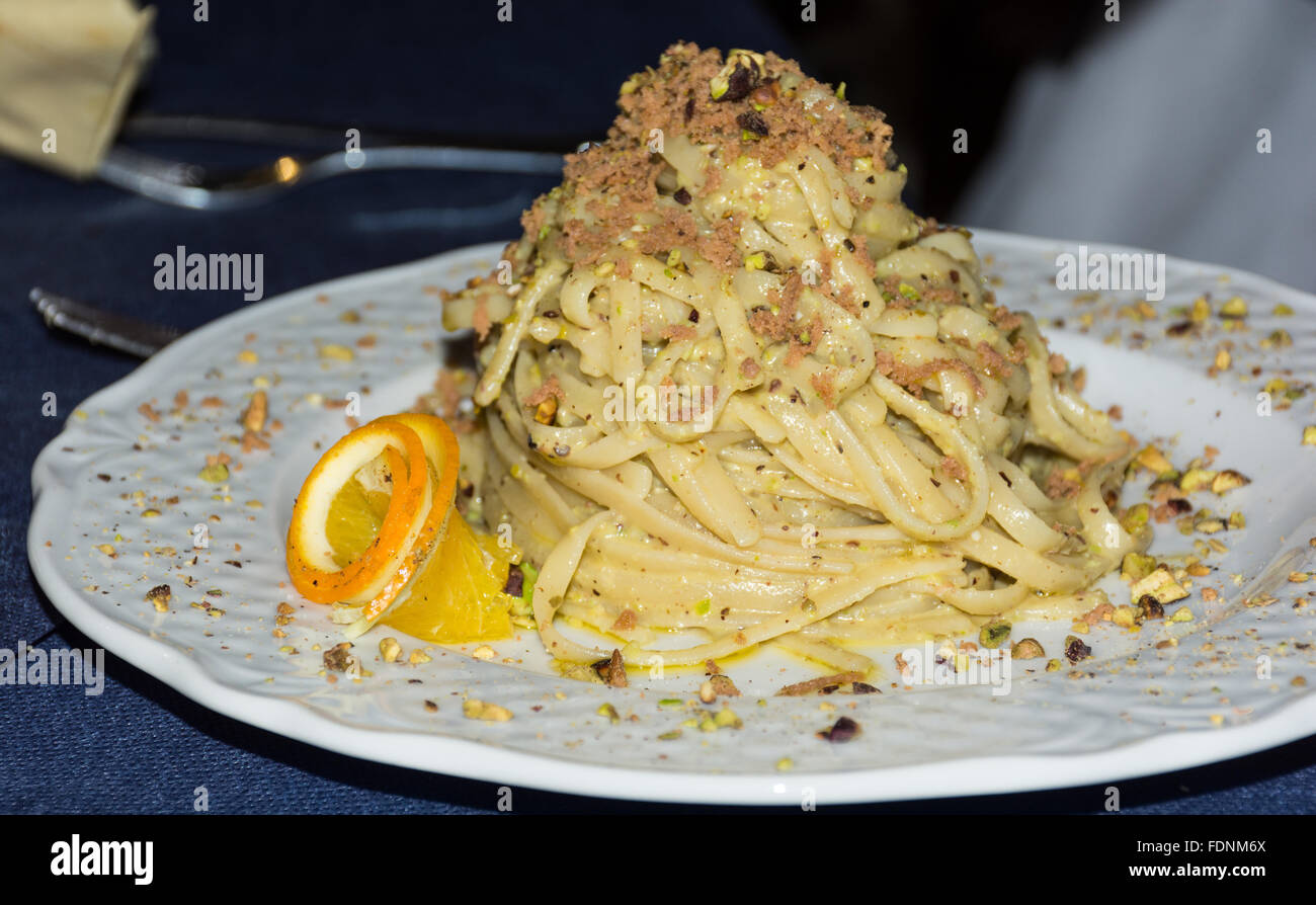 Piatto di Linguine con frutti di mare e pistacchi. Cucina tipica siciliana, la tradizione della dieta mediterranea. Foto Stock