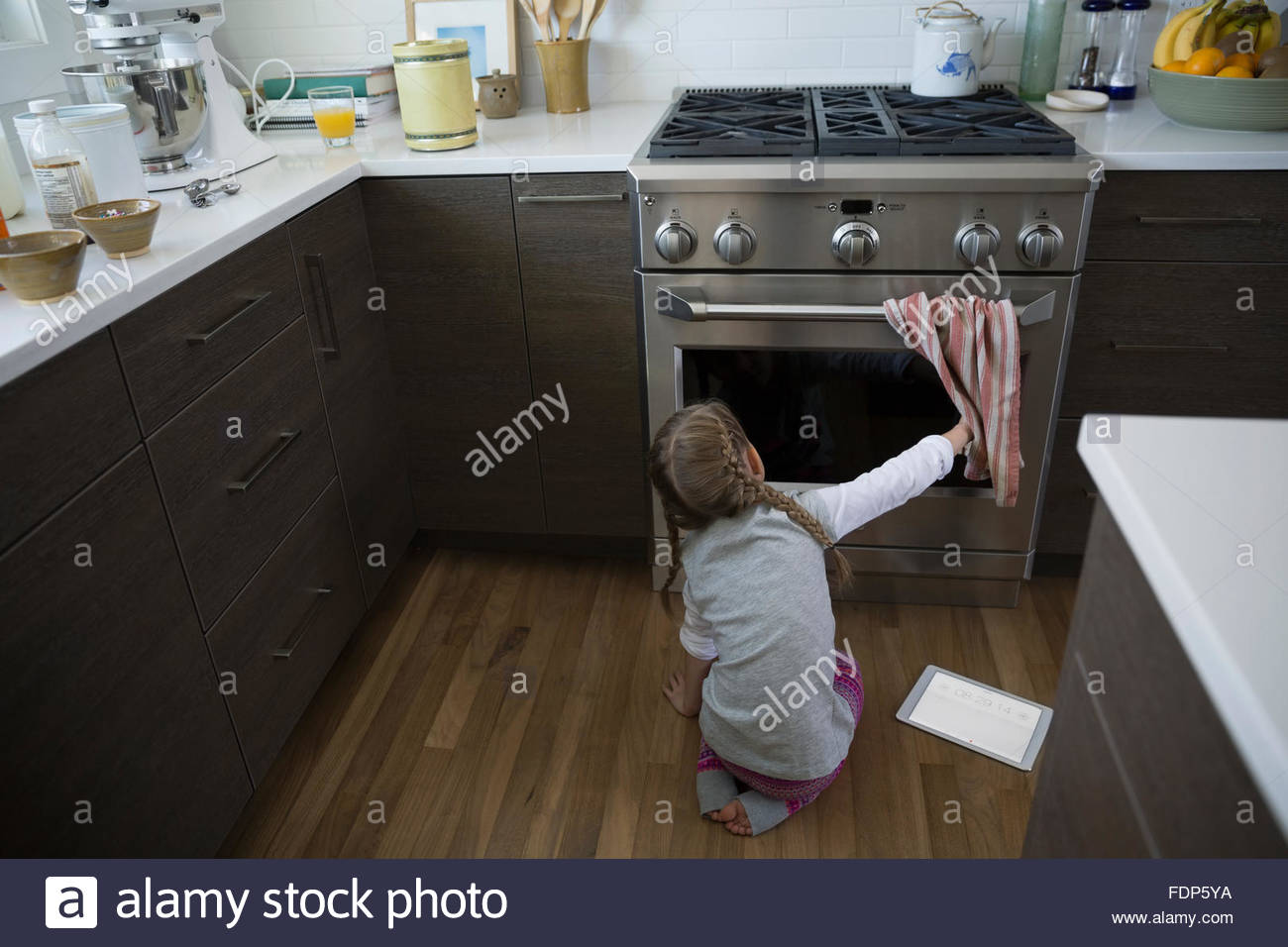 Ragazza del peering in forno in cucina Foto Stock