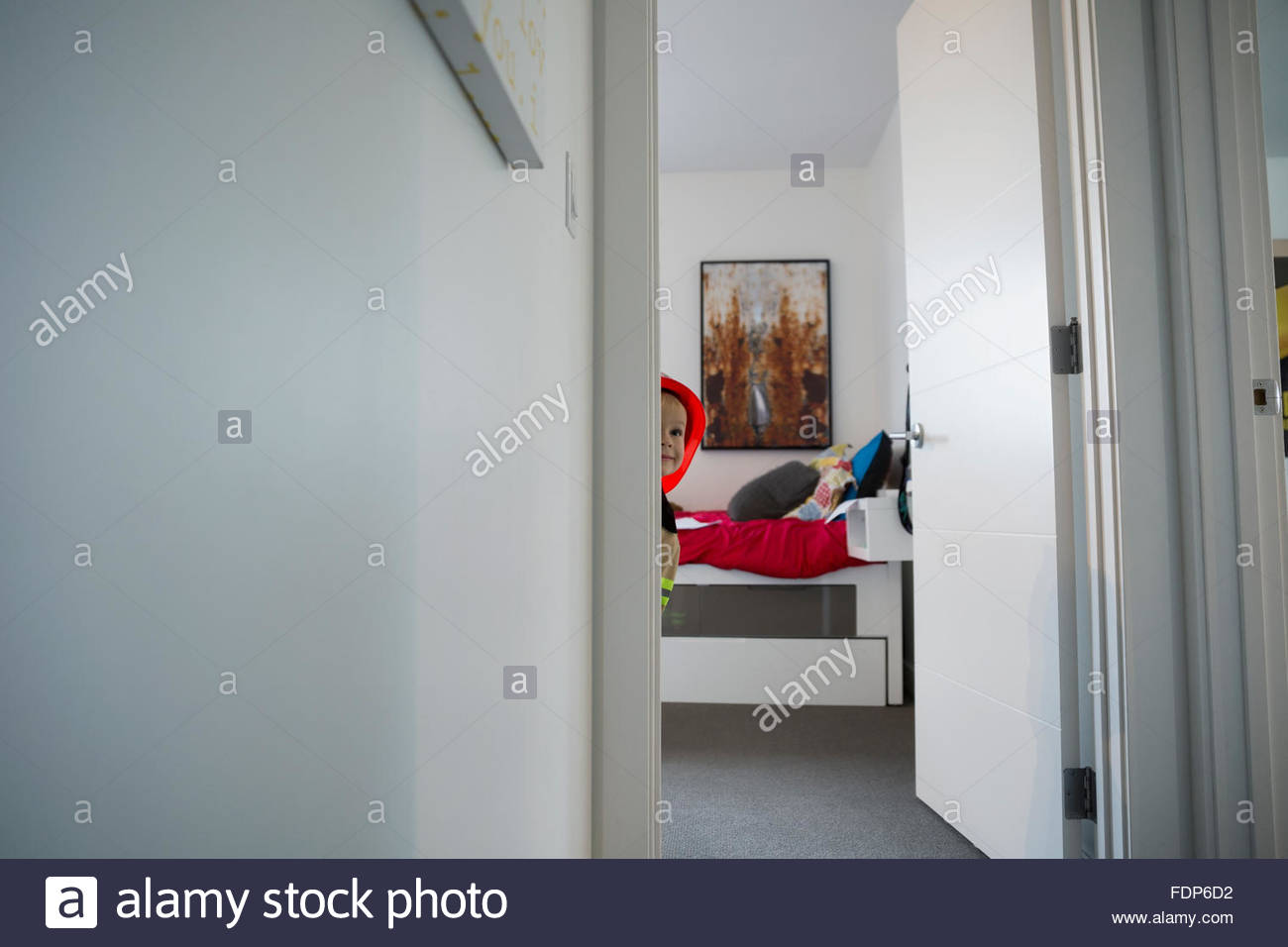 Ragazzo curioso il peering da camera da letto porta Foto Stock