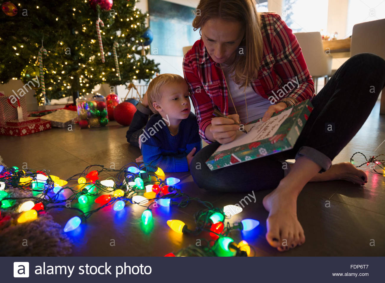 Madre e figlio facendo elenco Natale Luci di stringa Foto Stock