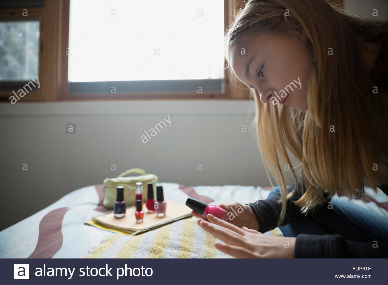 Ragazza pittura le unghie sul letto Foto Stock