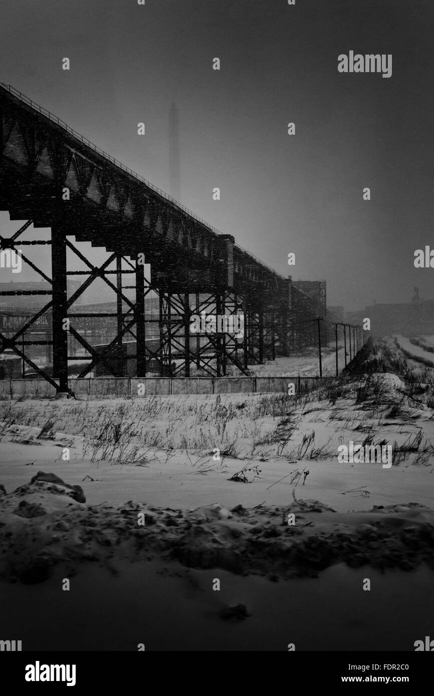 Invecchiamento abbandonata fabbrica vecchia immagine in bianco e nero in bianco e nero. L'inverno sfondo e guidando la neve crea un grunge styl Foto Stock