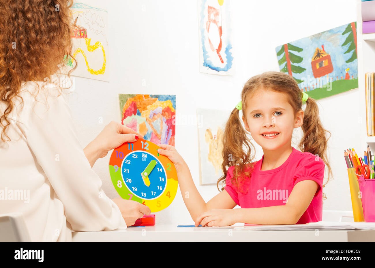 Ragazza tempo per lo studio con il cartone modello di orologio Foto Stock
