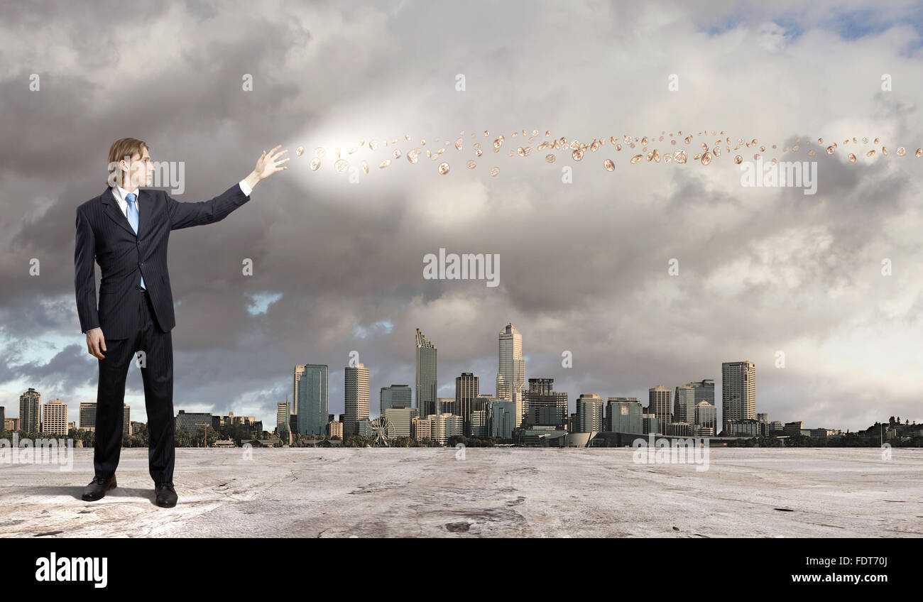 Imprenditore in tuta blu permanente e la giocoleria simboli aziendali Foto Stock