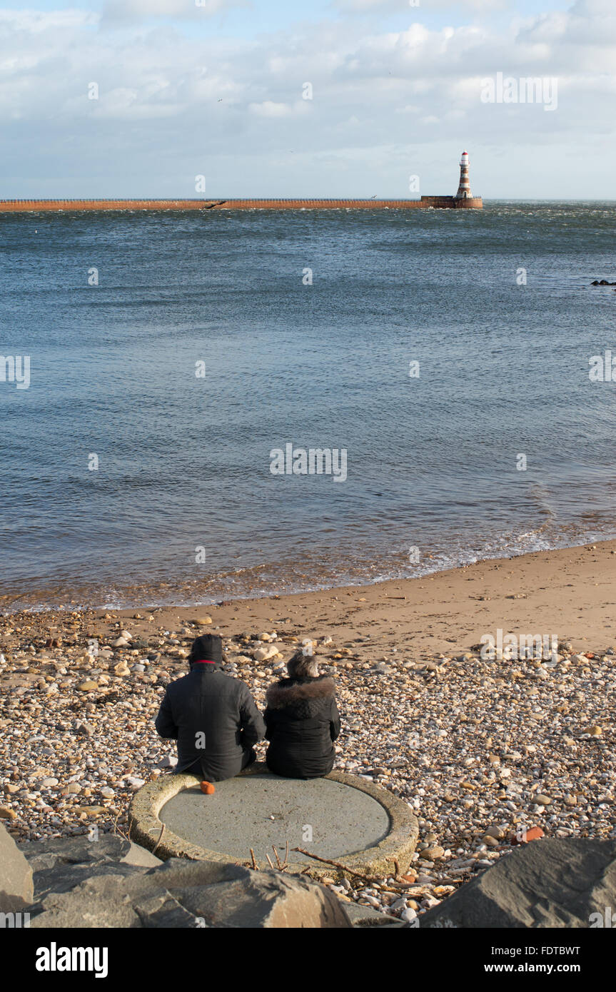 Coppia in pensione seduta che guarda al mare a Roker, Sunderland, North East England, Regno Unito Foto Stock
