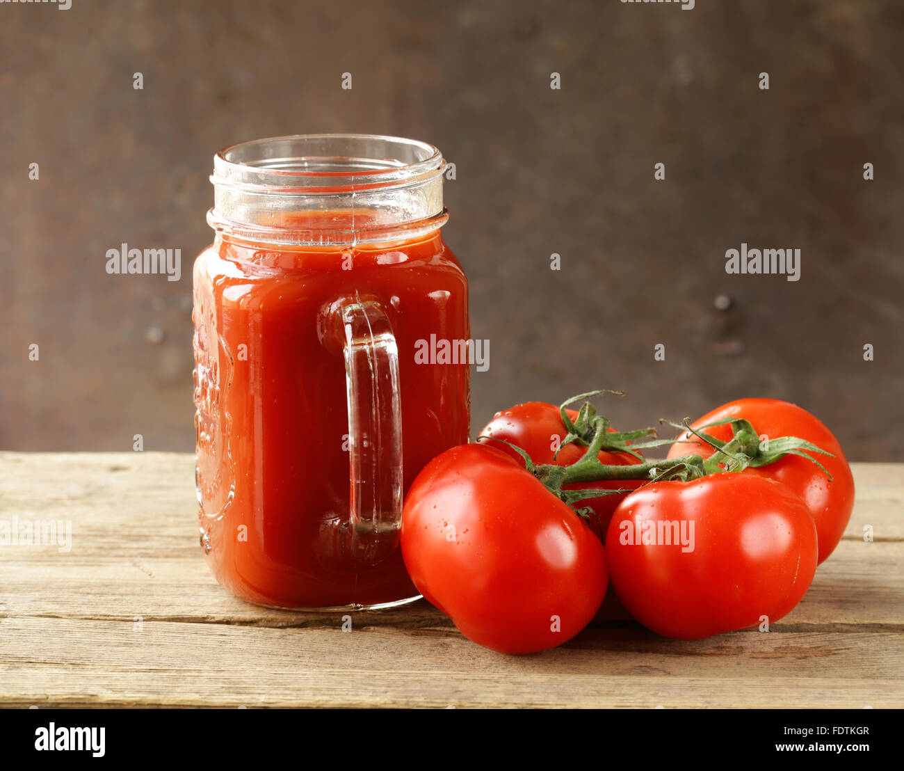 Il pomodoro fresco di succo in un vasetto di vetro sul tavolo Foto Stock