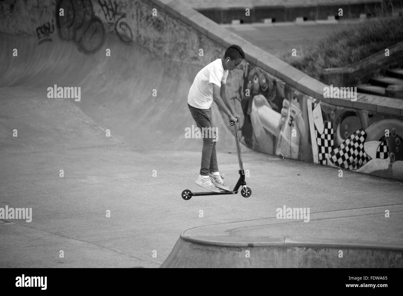 Trucchi su uno scooter in skate park Foto Stock