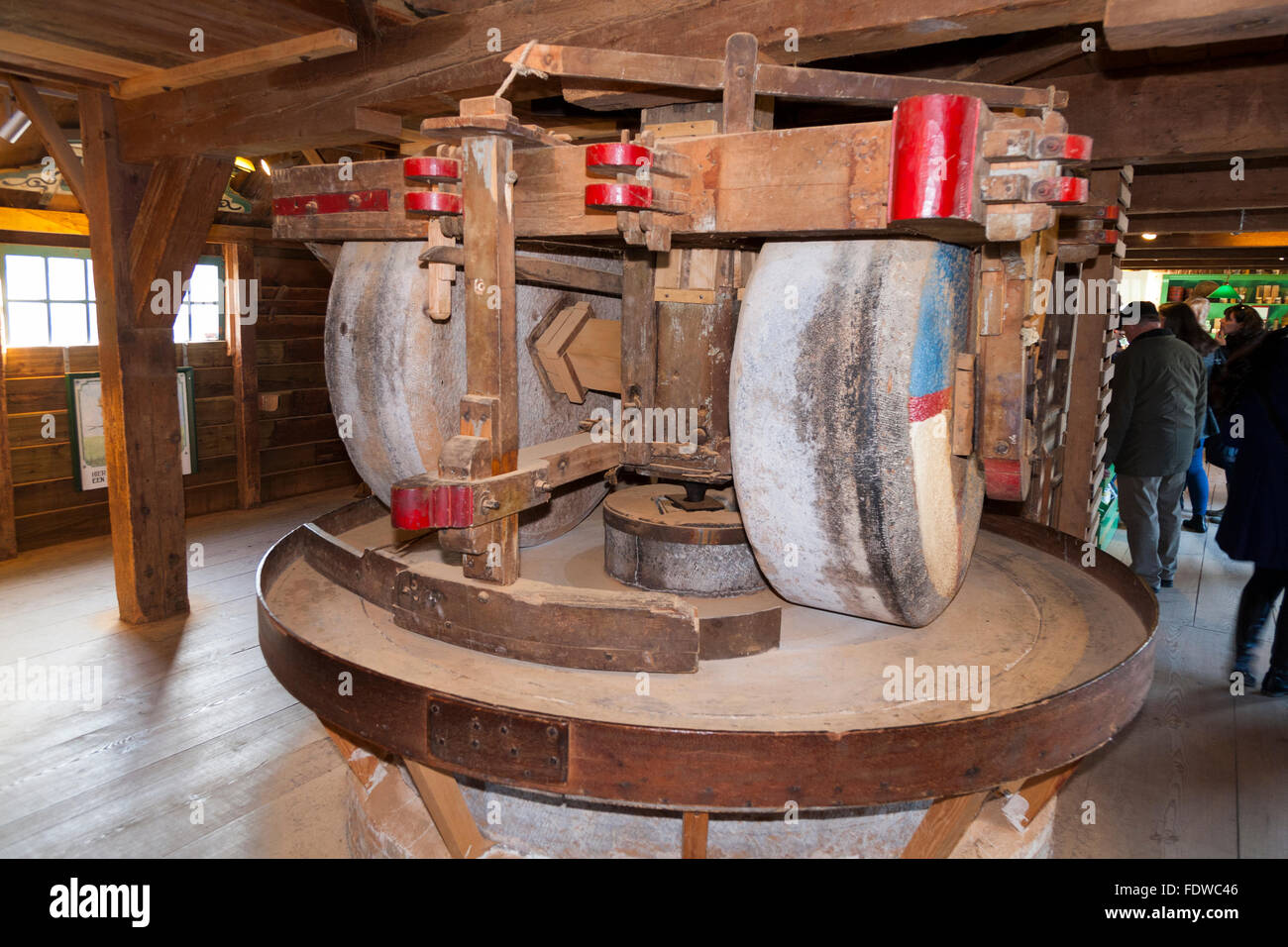 Il funzionamento all'interno del mulino a vento di spezie De Huisman, con tre coppie di macine da mulino mola ruote che macinare spezie varie. Zaanse Schans. Paesi Bassi Foto Stock