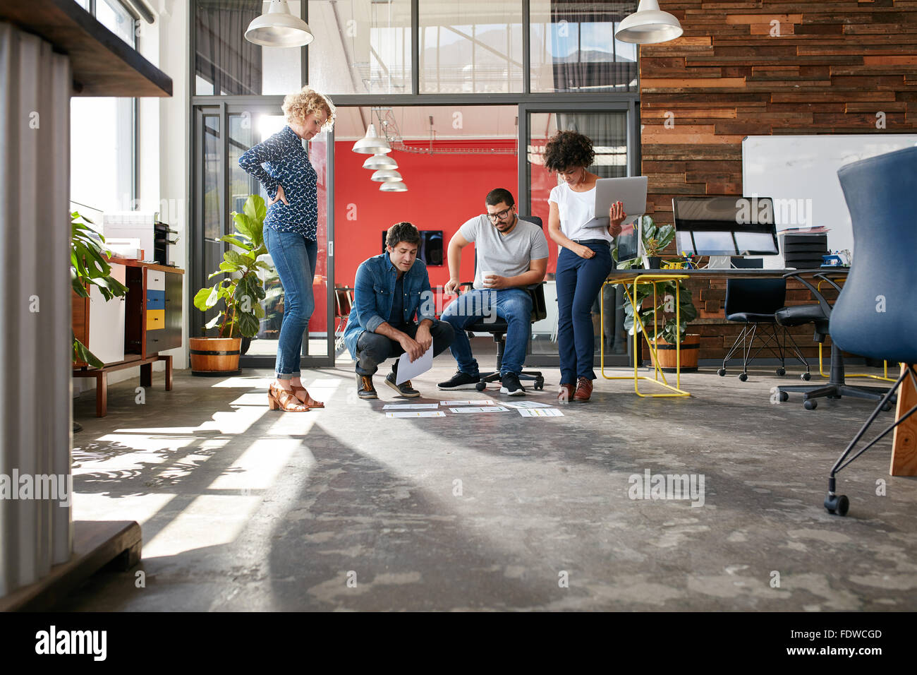 Razza mista gruppo di persone creative riunione in ufficio e discutere. Le persone creative che guardando i piani del progetto posa su flo Foto Stock