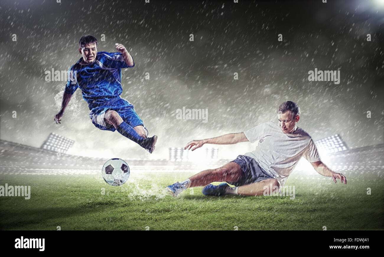 Due giocatori di calcio in salto per colpire la pallina presso lo stadio Foto Stock