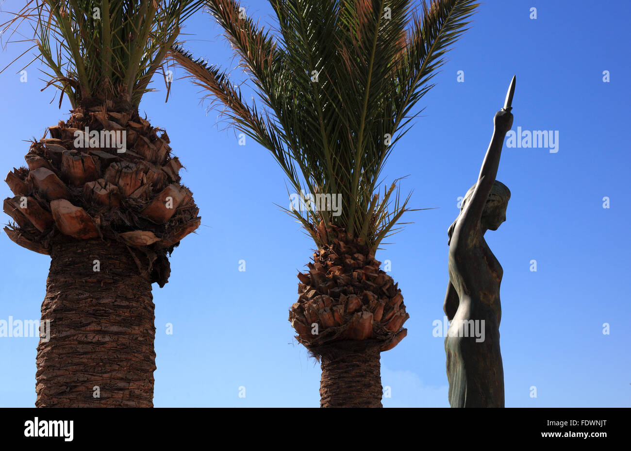 Creta, porto rethymno, palme e la statua che si trova nella città vecchia Foto Stock
