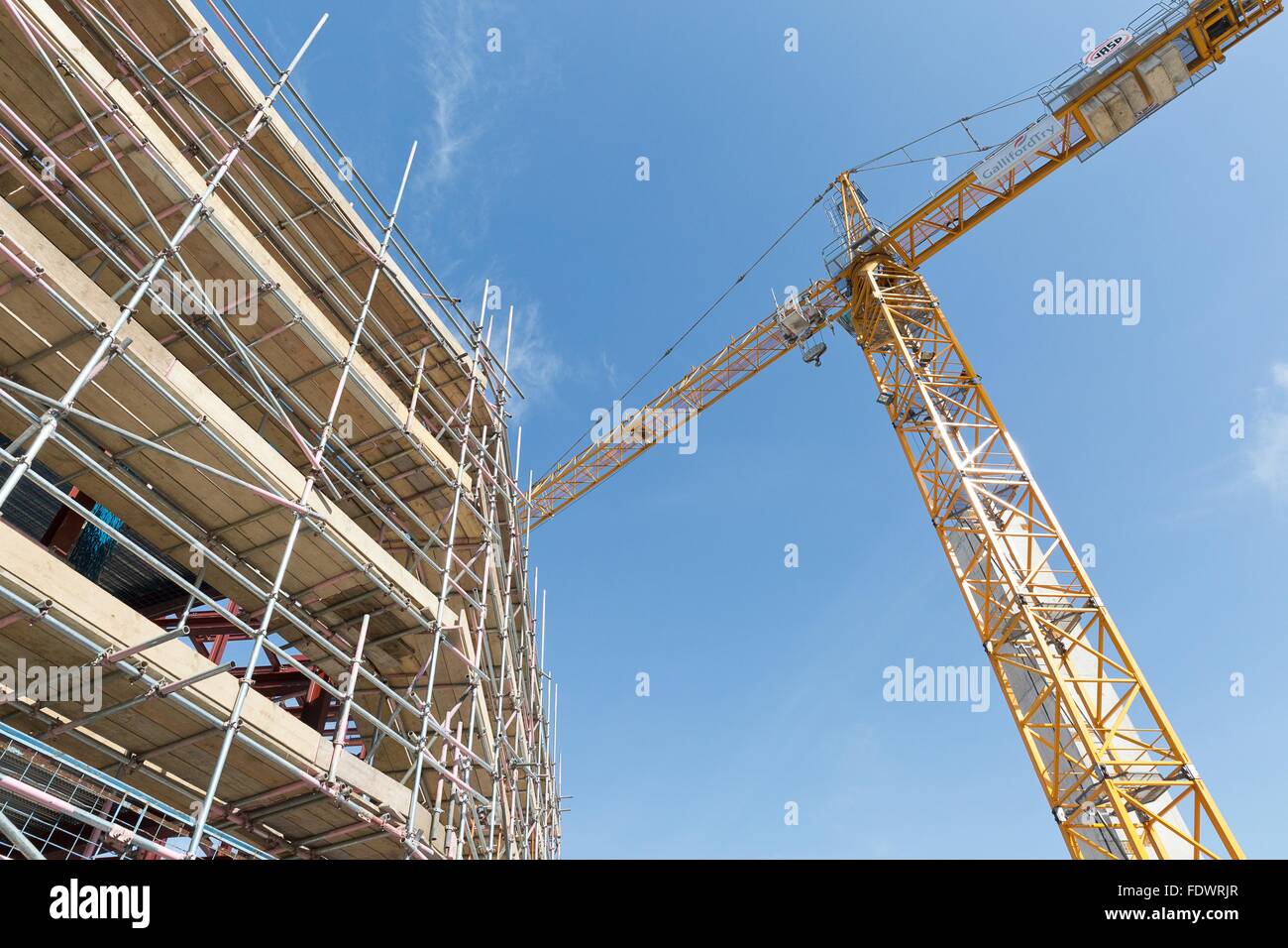 Un sito di costruzione con le lastre di cemento costruito tenute insieme con i ponteggi Foto Stock