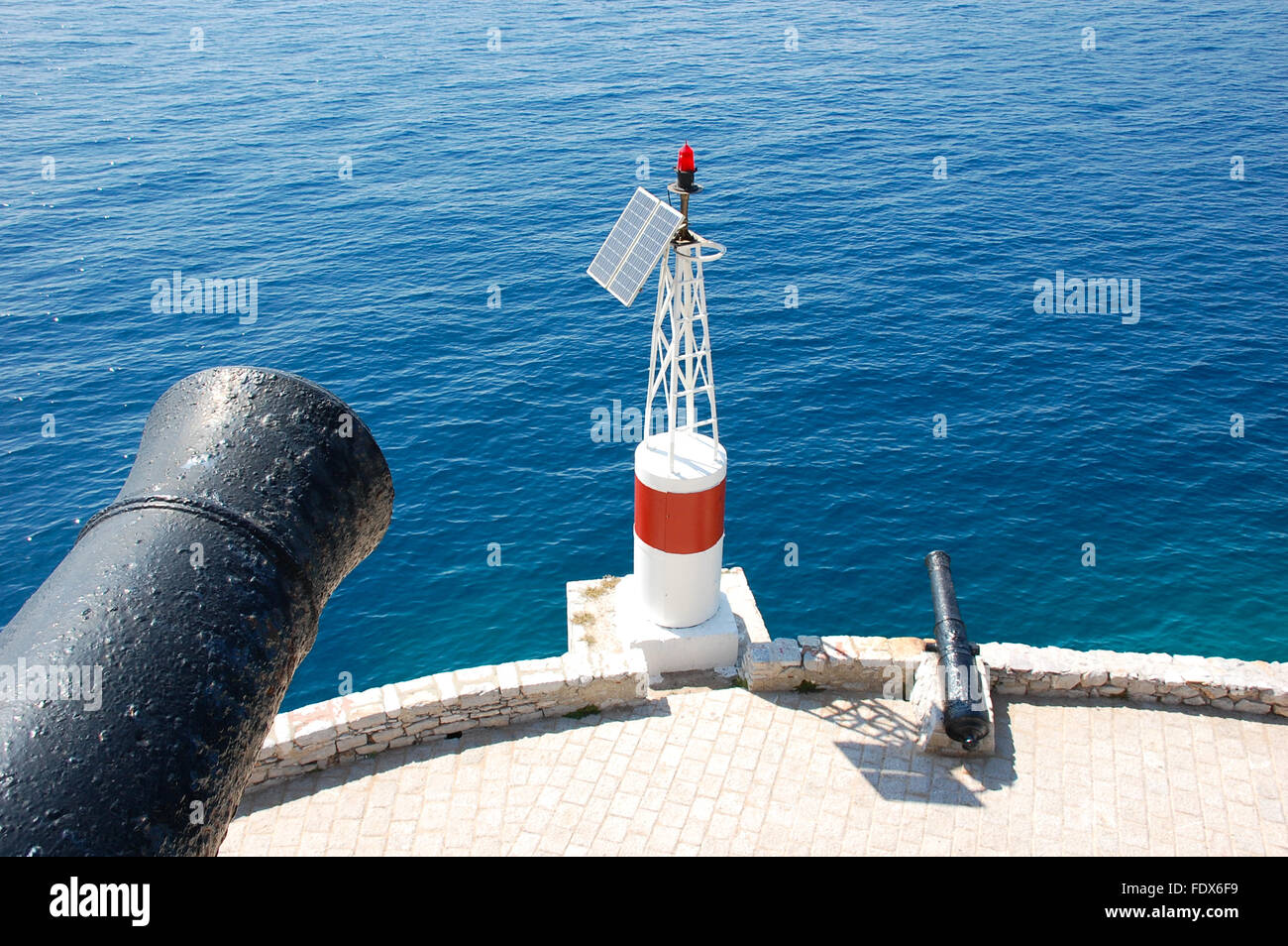 Piccola torre faro con cannoni a Hydra, Grecia Foto Stock