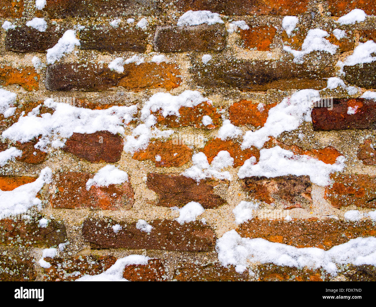Marrone Rosso mattone parete ricoperta con i fiocchi di neve Foto Stock