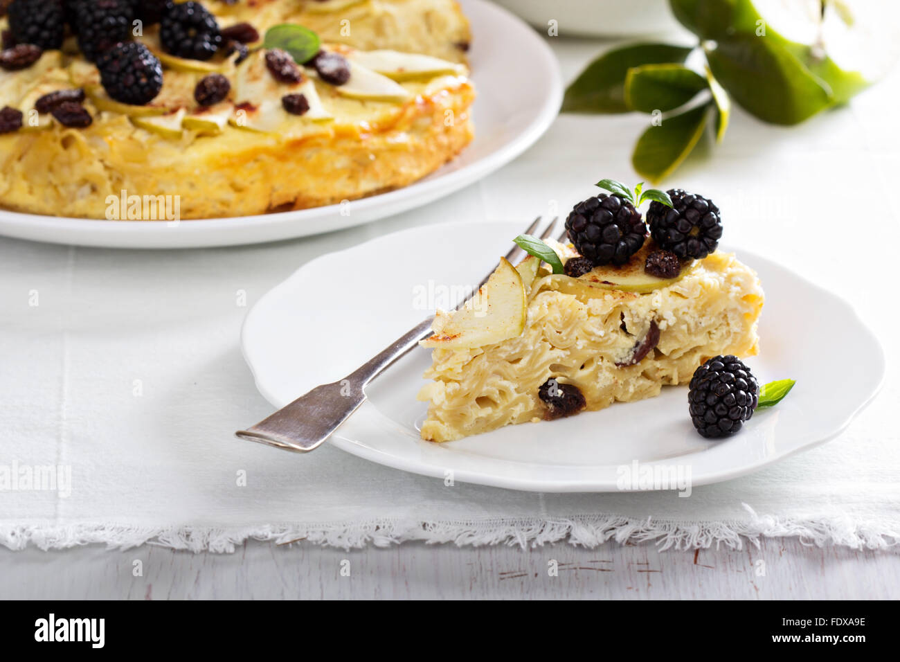 Kugel tradizionale piatto di pasta cotta al forno con torta di mele Foto Stock