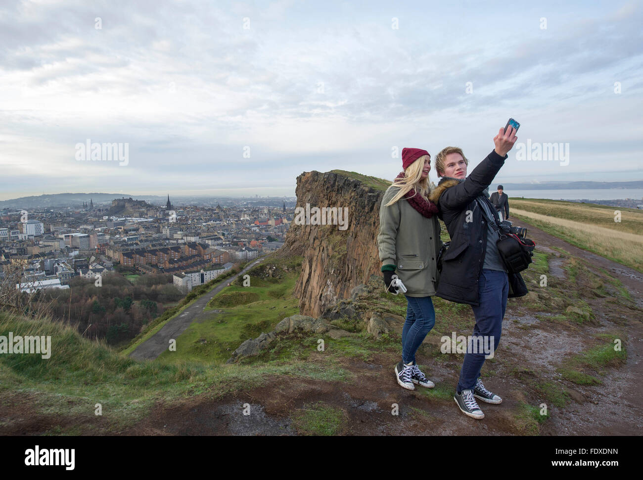 Edimburgo, Scozia, Regno Unito. Gli studenti norvegesi prendere un selfie su Salisbury Crags Holyrood Park con il Castello di Edinburgo e la città vecchia come sfondo. Foto Stock