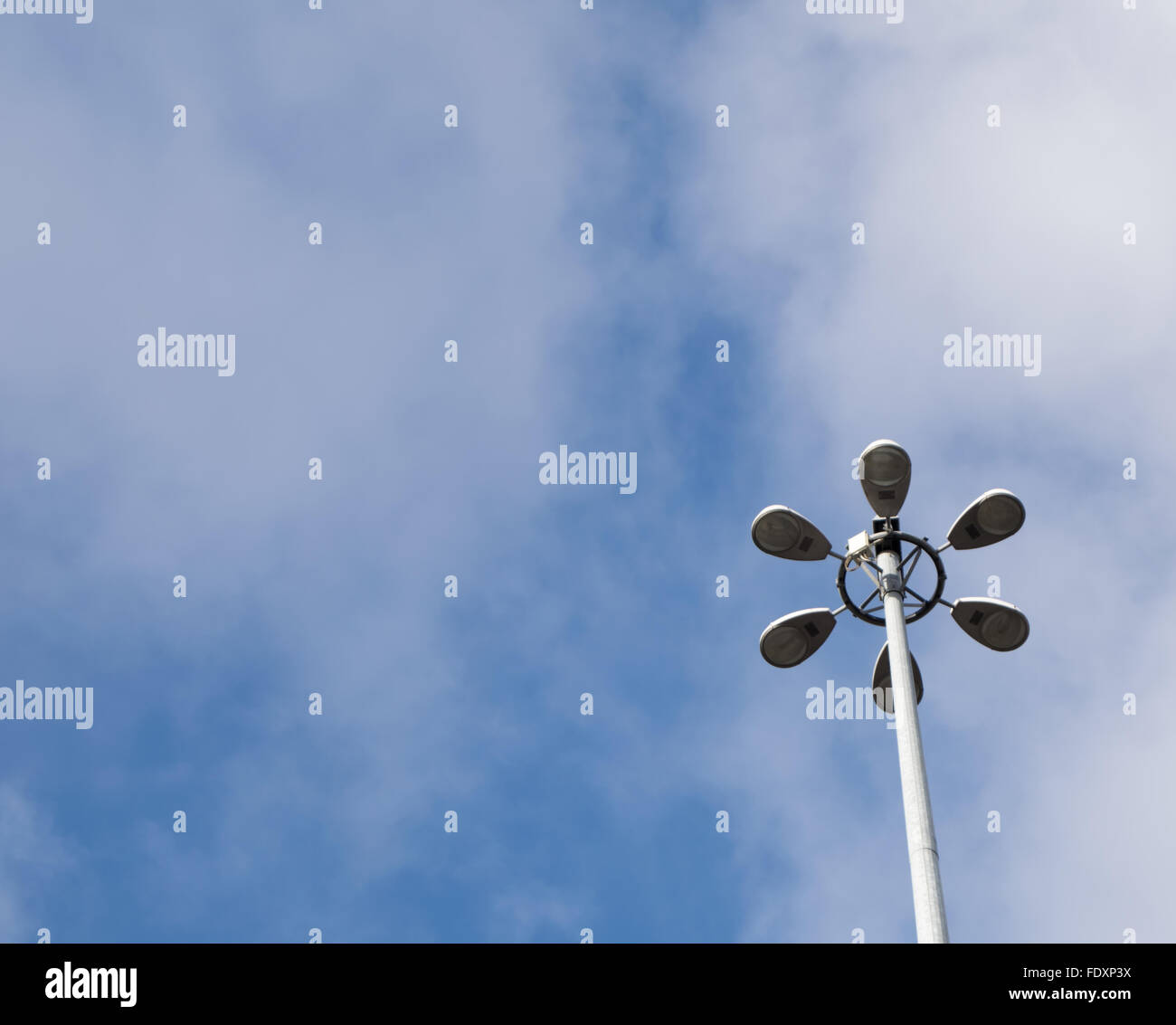 Un alto light set contro un cielo blu con alcune nuvole Foto Stock