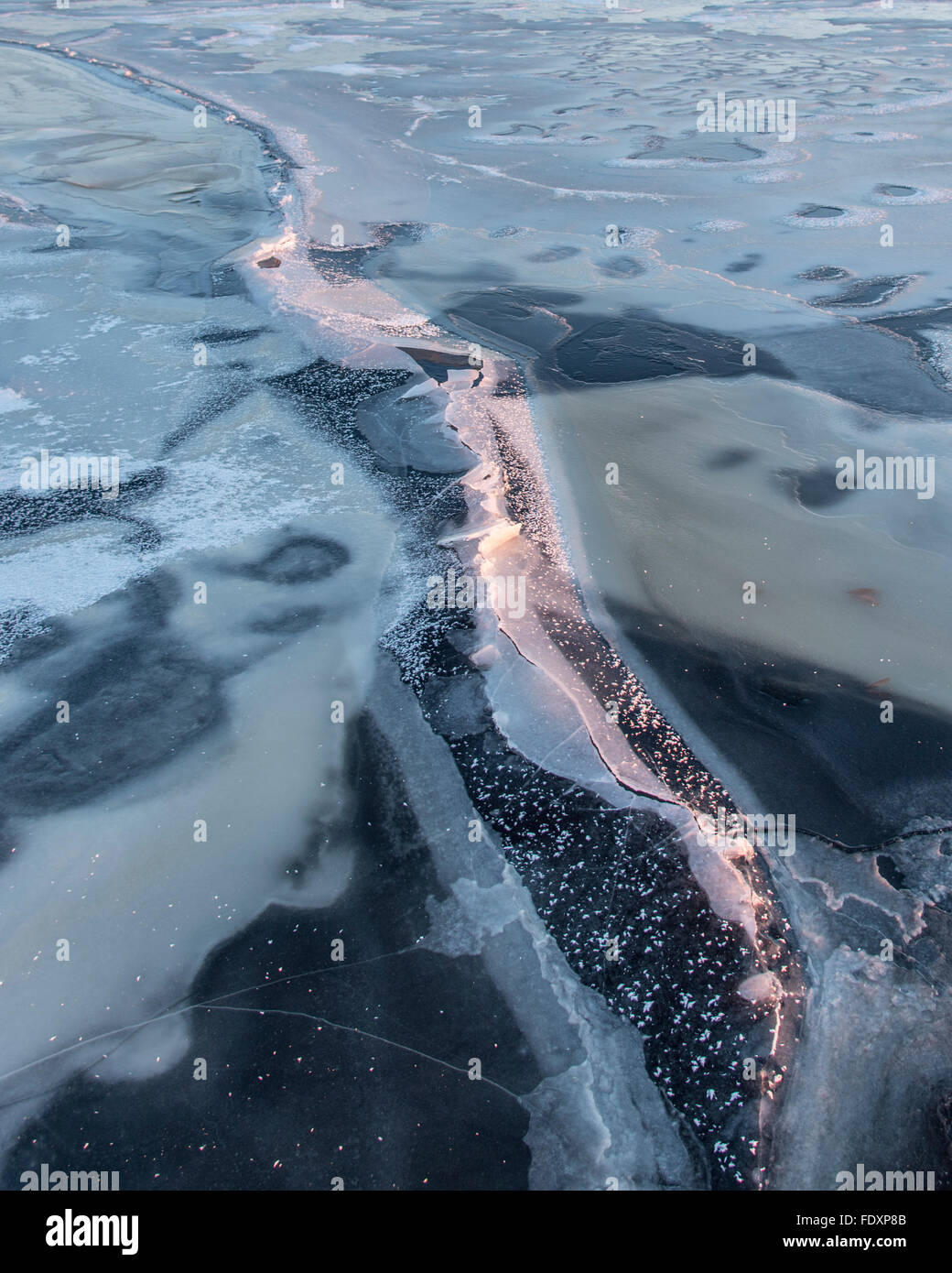 La formazione di crack sul ghiaccio molto sottile del grande lago Butte des morts. Foto Stock