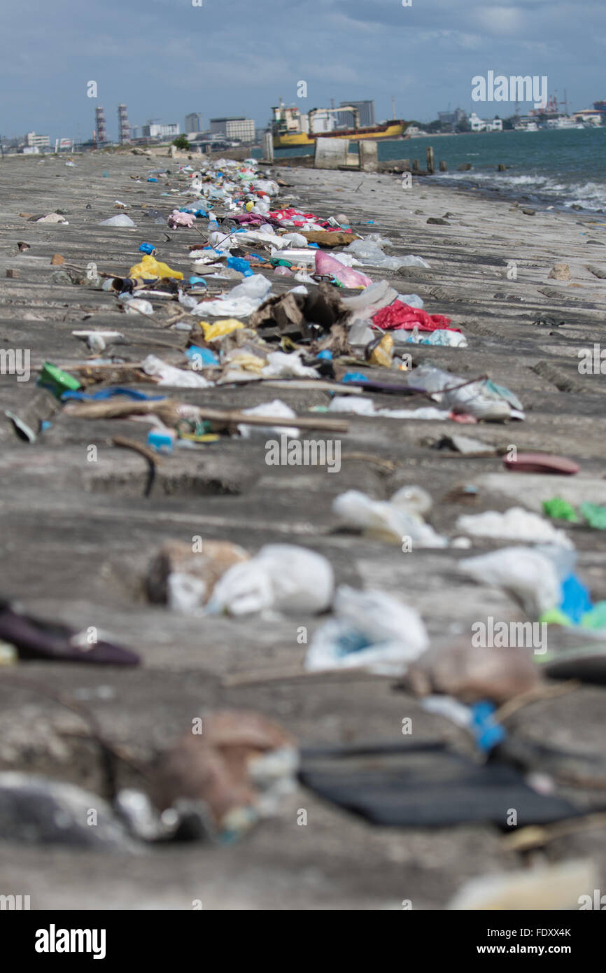 La marea si ritira lasciando una linea spessa principalmente di immondizia di plastica lungo il canale di spedizione le principali banche al Porto di Cebu,Phi Foto Stock