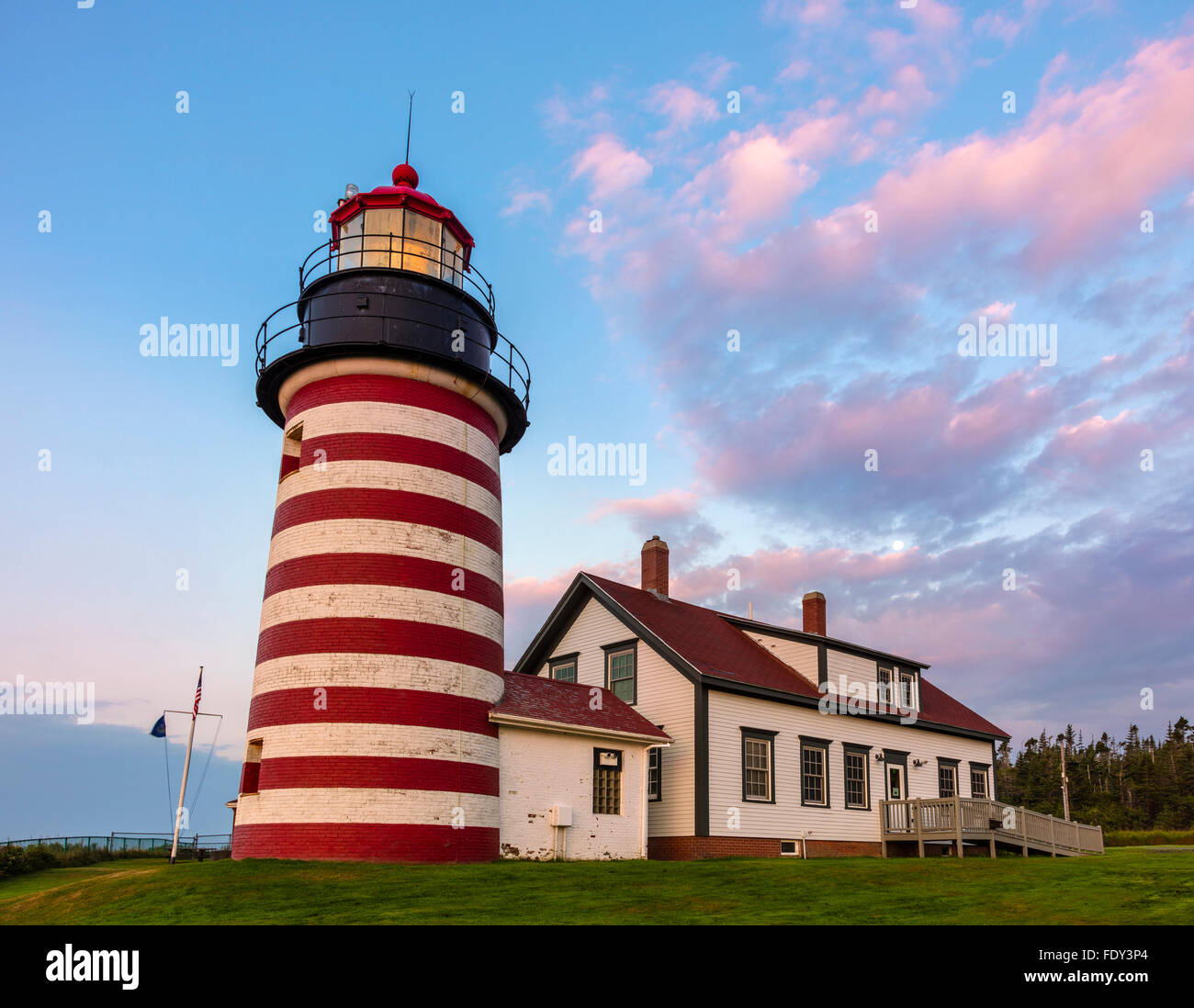 Lubec, Maine: West Quoddy Head Light all'alba con nuvole rosa e calare della luna. Foto Stock