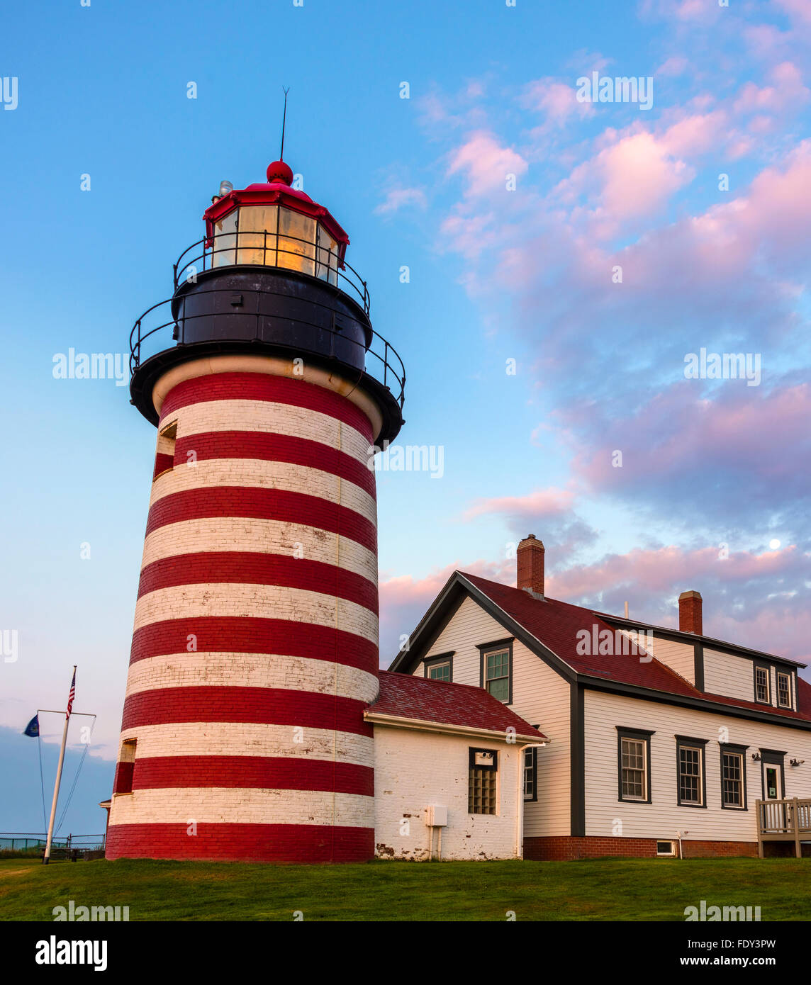 Lubec, Maine: West Quoddy Head Light all'alba con nuvole rosa e calare della luna. Foto Stock