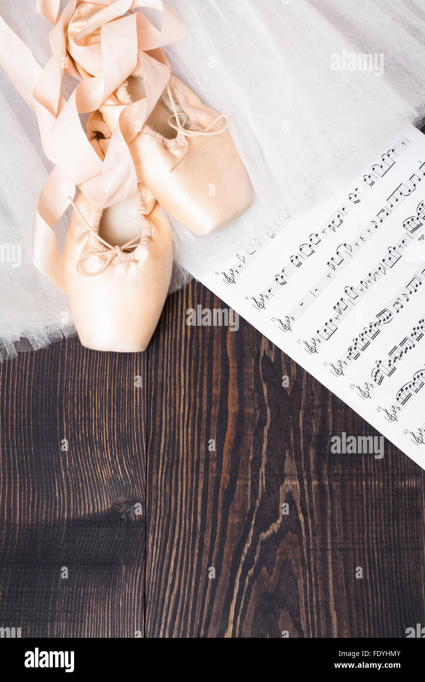Scarpe da ballo, mantello e foglio di musica su un sfondo di legno Foto Stock