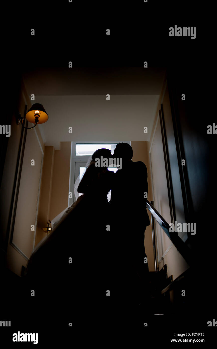 Sposa e lo sposo baciare silhouette sul loro matrimonio Foto Stock