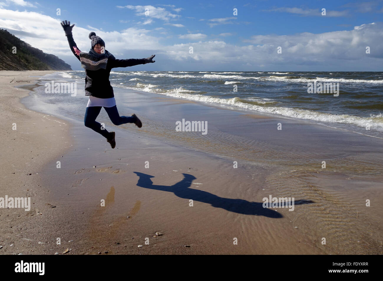 Kolberg, Polonia, donna fare un salto in aria sulla spiaggia Foto Stock