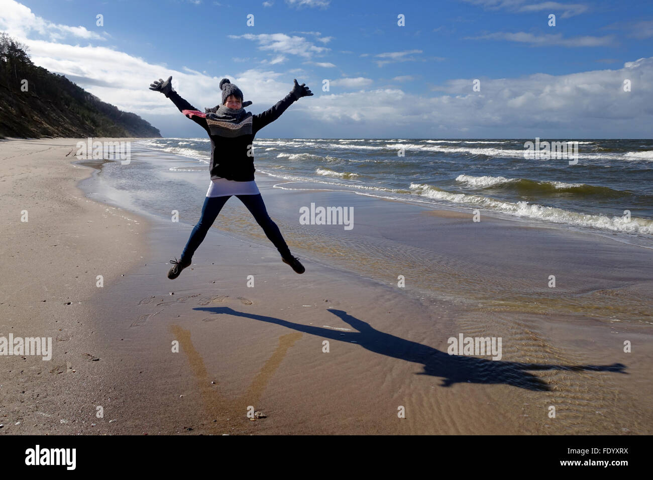 Kolberg, Polonia, donna fare un salto in aria sulla spiaggia Foto Stock