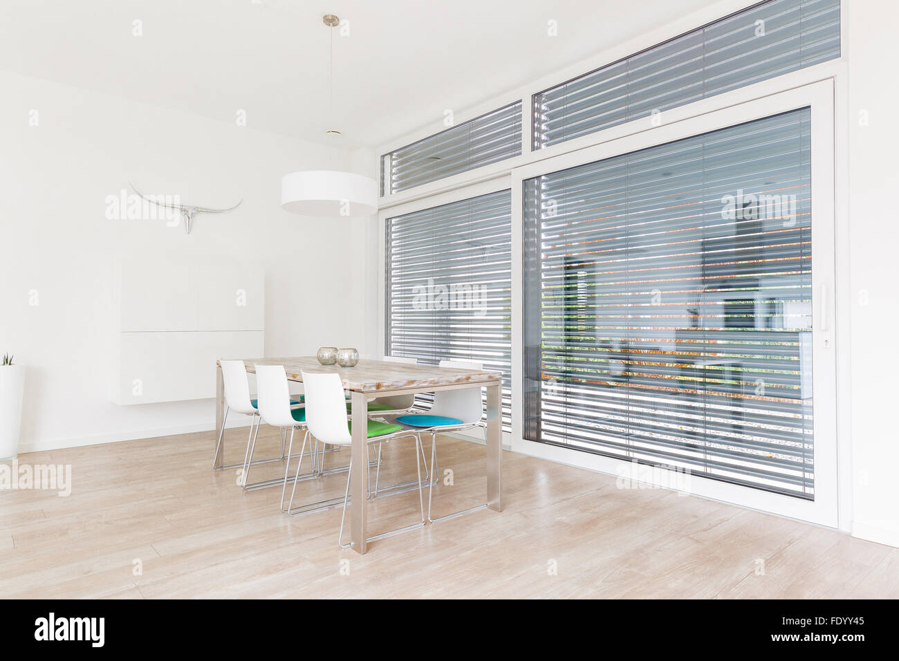 Interno di una luminosa e moderna sala da pranzo con grandi finestre Foto Stock