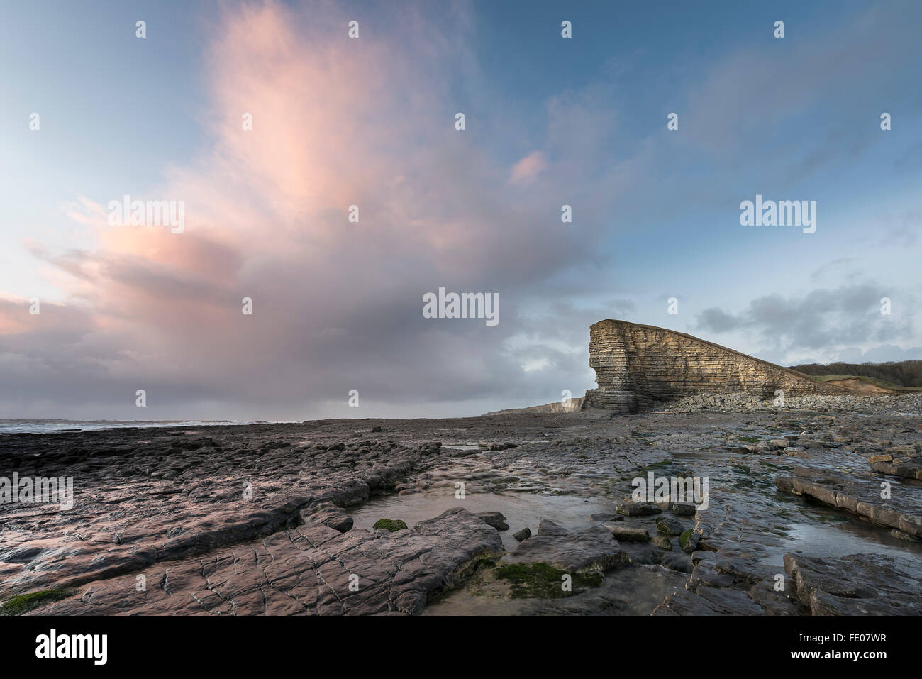 Punto di Nash con rocce di primo piano e di tramonto in inverno Foto Stock