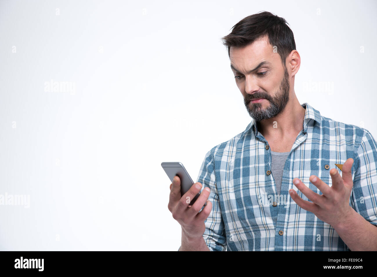 Angry man tenendo lo smartphone isolato su uno sfondo bianco Foto Stock