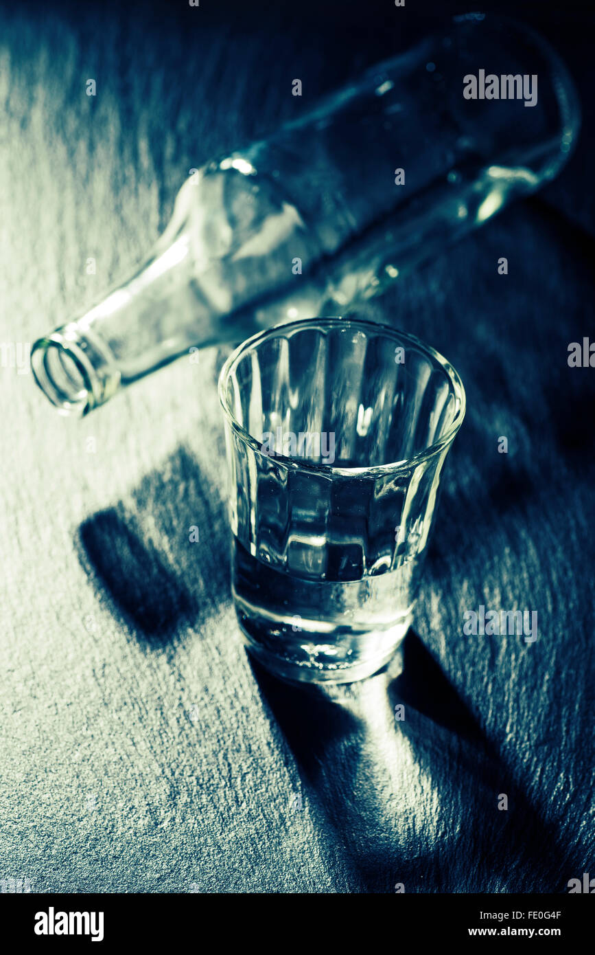 Il vetro con il liquore e la bottiglia vuota Foto Stock
