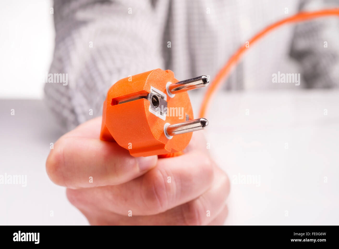 Mano con la spina di un apparecchio elettrico Foto Stock