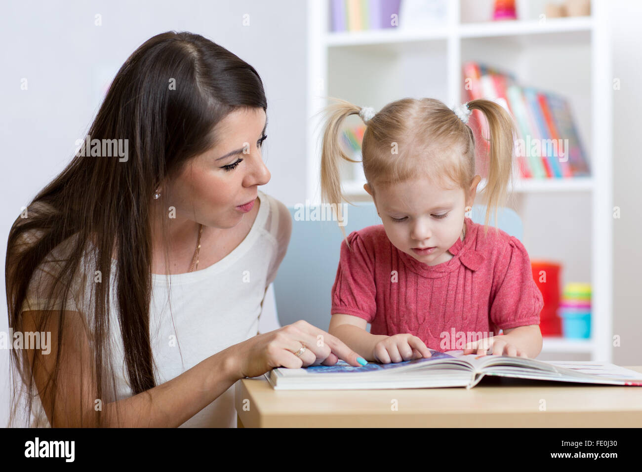 Ragazzo e una ragazza madre di leggere un libro in ambienti interni Foto Stock