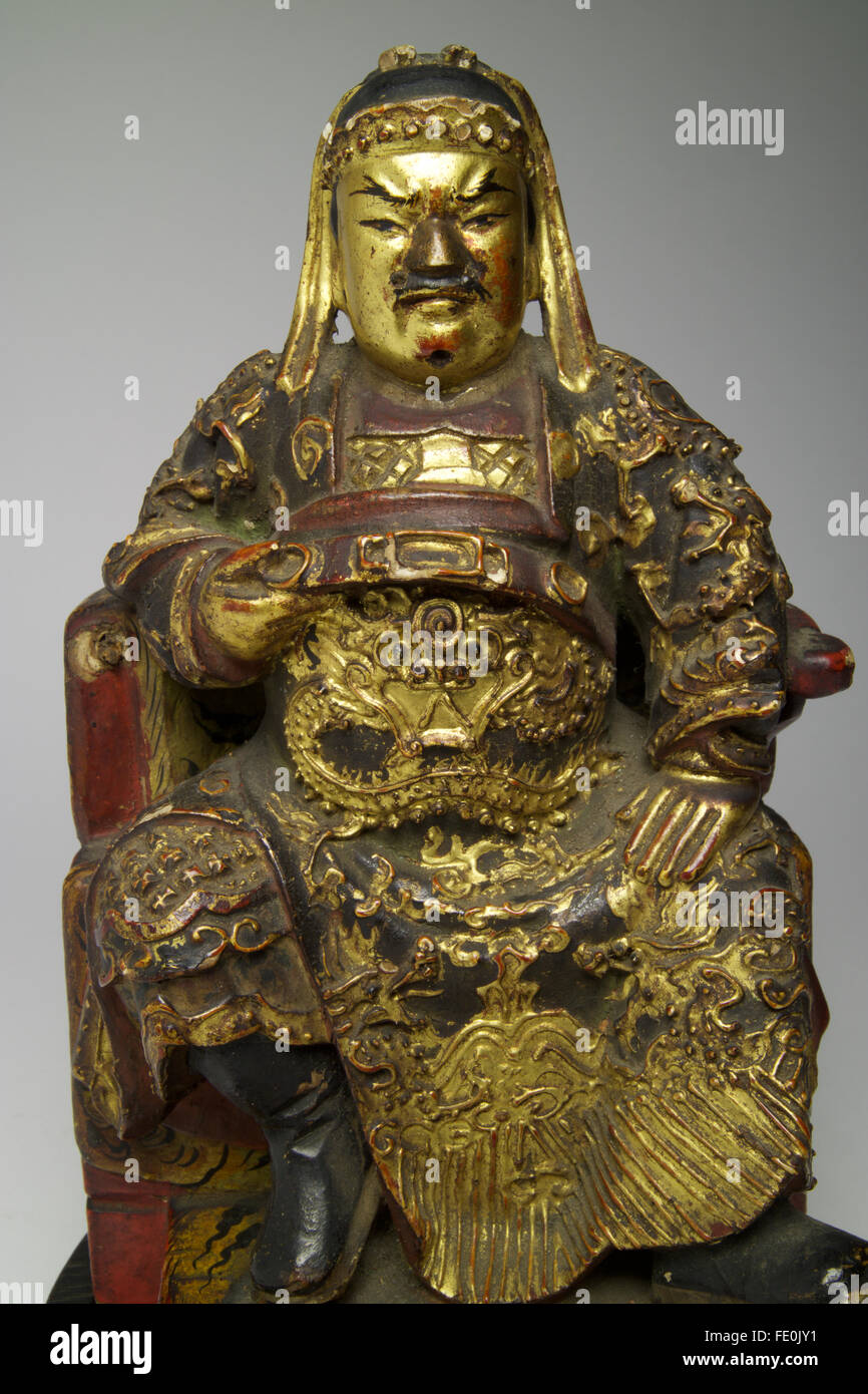Cinese antichi policromi in legno laccato figura di Guandi rappresentato seduto con una mano sollevata e stringendo la cinghia. Guandi è Foto Stock