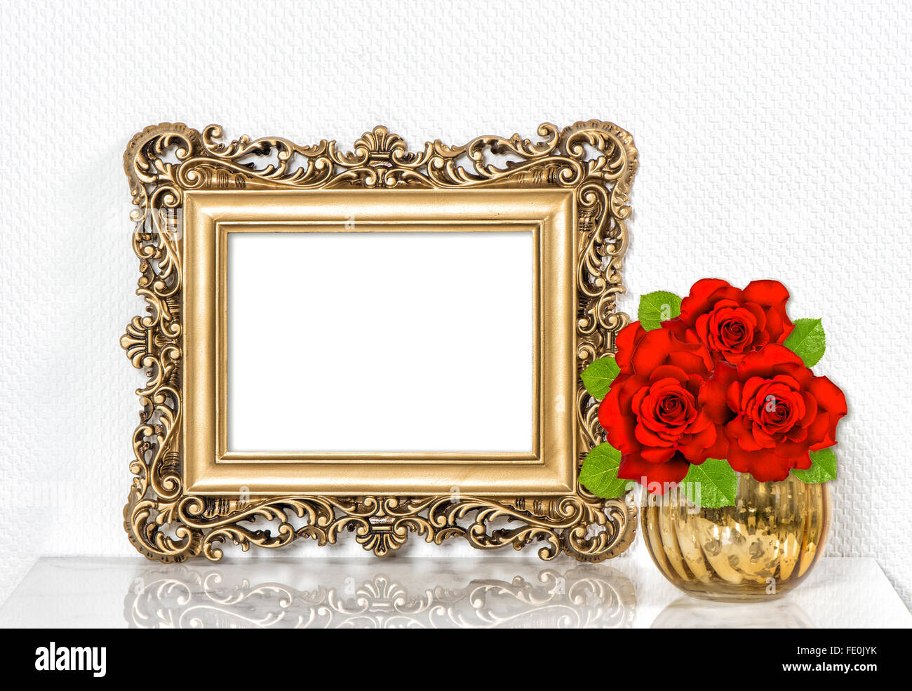 Golden picture frame e rose rosse fiori. In stile vintage decorazione con lo spazio per il tuo testo o immagine Foto Stock